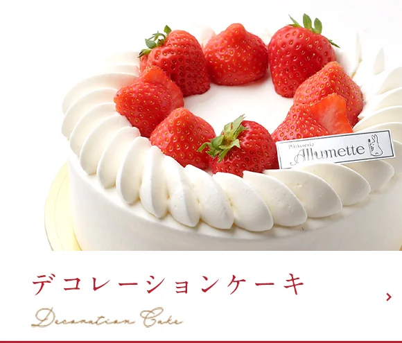 クリームと果物を飾ったデコレーションケーキを仕上げる手元