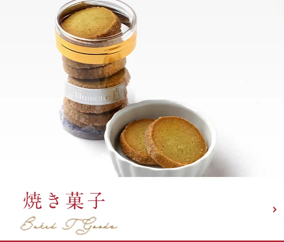 木のテーブルに並べたフィナンシェやクッキーなどの焼き菓子の詰め合わせ